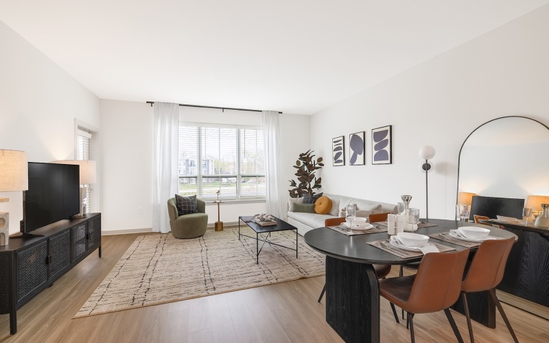 living area with a dining table and chairs and large windows