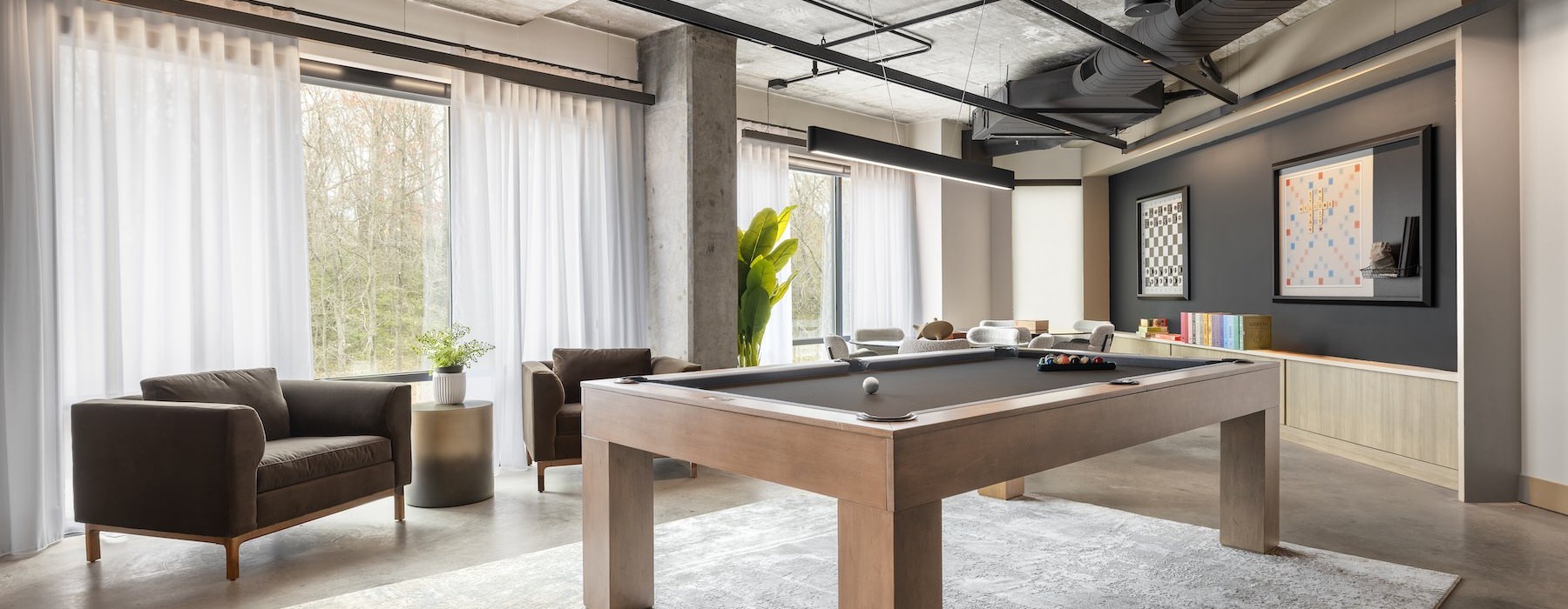 a room with a pool table and chairs