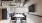 a room with a fridge, tables and chairs