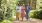 Three active adults walking and holding cups of juice on a trail near our senior living community in South Jersey.